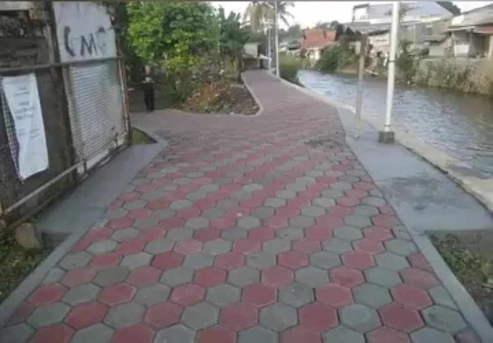 Jalur pedestrian paving hexagon merah abu tepi sungai